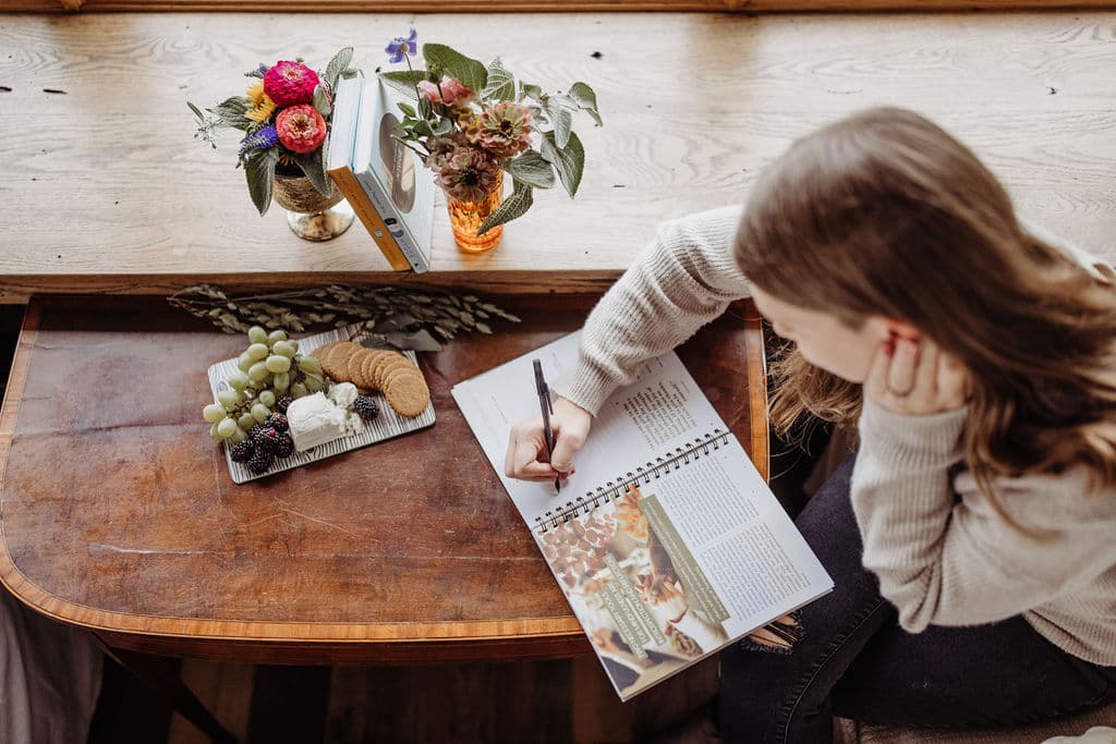 Woman using JMB Living Journal for intentional journaling